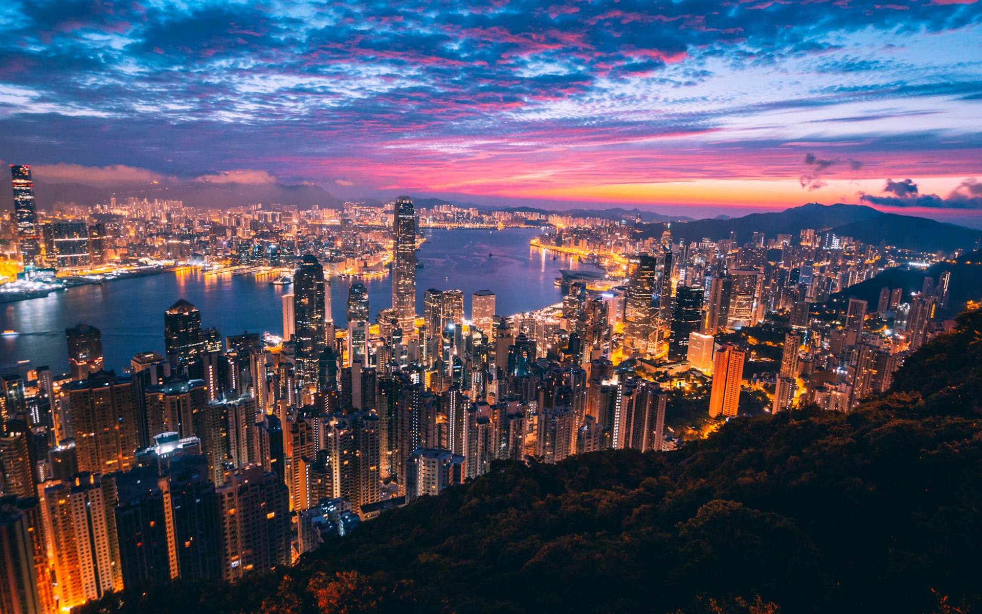 Hong Kong and Macau twin-city skyline glowing over the water at dusk